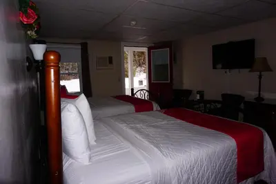 a hotel room with two beds and a television at Stay Berkshires in Williamstown
