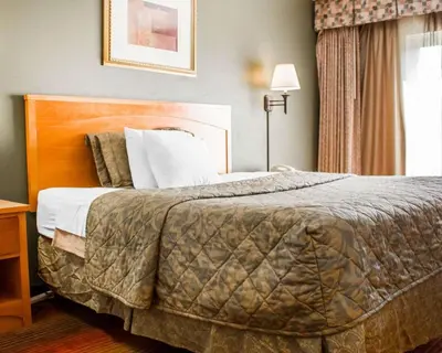 a hotel room with a large bed and a window at Rodeway Inn Huntington Station - Melville in Huntington