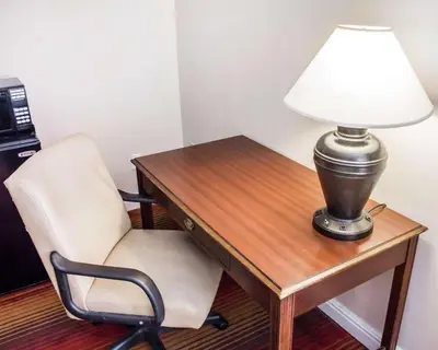a desk with a chair and a lamp on it at Rodeway Inn Huntington Station - Melville in Huntington