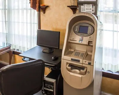 an atm machine next to a desk with a computer at Rodeway Inn Huntington Station - Melville in Huntington