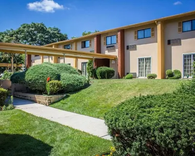 a large building with a lawn in front of it at Rodeway Inn Huntington Station - Melville in Huntington