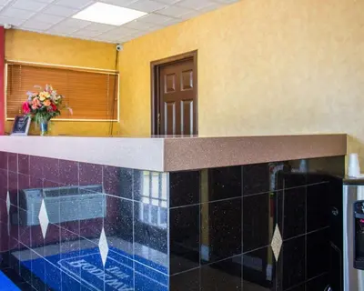 a kitchen with a counter top with blue tile at Rodeway Inn Huntington Station - Melville in Huntington