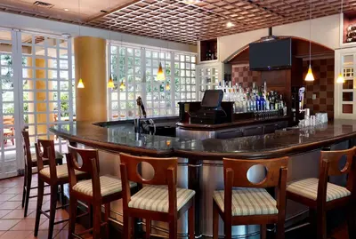 a bar in a restaurant with chairs around it at Embassy Suites Parsippany in Parsippany