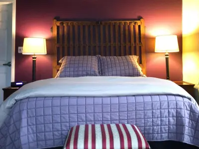 a bedroom with a large bed with two lamps at The Inn At Stone Mill in Little Falls