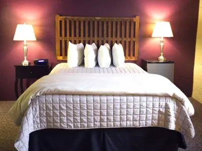 a bedroom with a large bed with two lamps at The Inn At Stone Mill in Little Falls