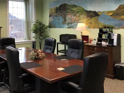 a conference room with a wooden table and chairs at The Inn At Stone Mill in Little Falls