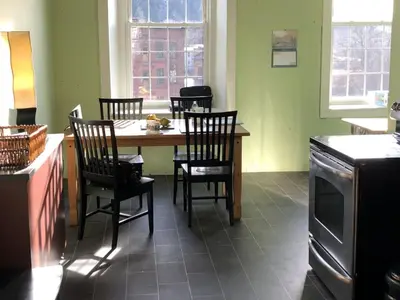 a kitchen with a wooden table with chairs and a tableasteryasteryasteryasteryastery at The Inn At Stone Mill in Little Falls