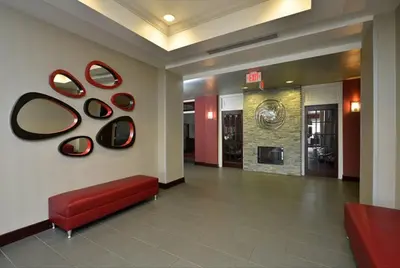 a lobby with a red bench and mirrors on the wall at Holiday Inn Express & Suites Utica by IHG in Utica