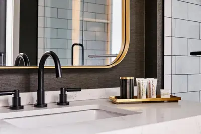a sink with two faucets and a mirror at The Blake Hotel in New Haven