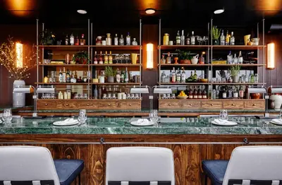 a bar with white chairs in a restaurant at The Blake Hotel in New Haven