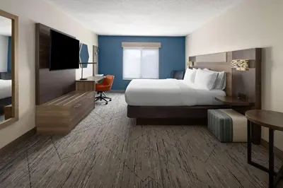 a hotel room with a bed and a flat screen tv at Holiday Inn Express and Suites Meriden by IHG in Meriden