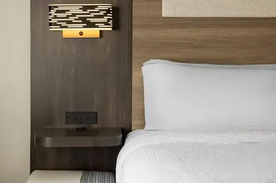 a bedroom with a bed and a clock on the wall at Holiday Inn Express and Suites Meriden by IHG in Meriden