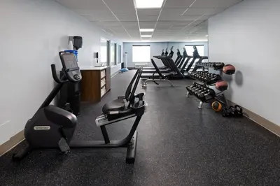 a gym with a row of exercise bikes and treadmills at Holiday Inn Express and Suites Meriden by IHG in Meriden