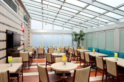 a dining room with tables and chairs and a tv at Holiday Inn Express - Times Square South by IHG in New York