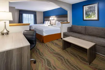 a hotel room with a bed and a couch at Baymont by Wyndham Budd Lake in Budd Lake