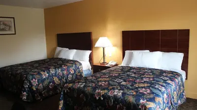 a hotel room with two beds and a lamp at Passport Inn and Suites - Middletown in Middletown