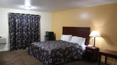 a hotel room with a bed and a window at Passport Inn and Suites - Middletown in Middletown