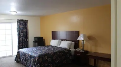 a hotel room with a bed and a window at Passport Inn and Suites - Middletown in Middletown
