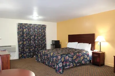 a hotel room with a bed and a window at Passport Inn and Suites - Middletown in Middletown