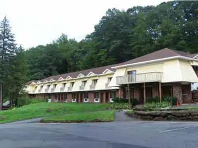 a large building with a parking lot in front of it at Passport Inn and Suites - Middletown in Middletown