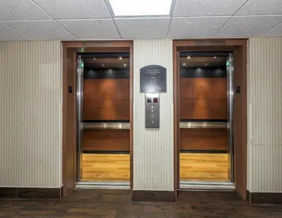 a row of elevators in a building with wooden doors at Red Roof Inn Hartford- New Britain in New Britain