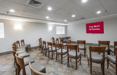 a room with chairs and a sign that reads free wifi at rooms at Red Roof Inn Hartford- New Britain in New Britain