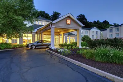 a car parked in front of a building with a clock at Hilton Garden Inn Norwalk in Norwalk