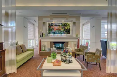 a living room with a couch and a fireplace at Hilton Garden Inn Norwalk in Norwalk