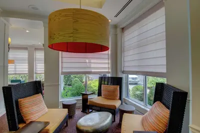 a living room with chairs and a large window at Hilton Garden Inn Norwalk in Norwalk