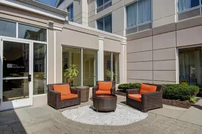 a group of chairs sitting outside of a building at Hilton Garden Inn Norwalk in Norwalk