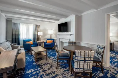 a hotel room with a table and chairs and a living room at Crowne Plaza Albany - The Desmond Hotel in Albany