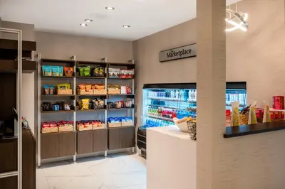 a grocery store with a refrigerator and shelves with food at Crowne Plaza Albany - The Desmond Hotel in Albany