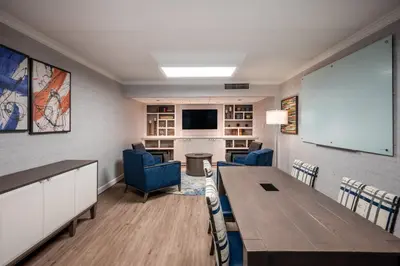 a conference room with a table and chairs and a screen at Crowne Plaza Albany - The Desmond Hotel in Albany
