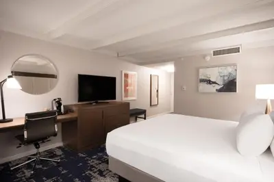 a hotel room with a bed and a desk with a television at Crowne Plaza Albany - The Desmond Hotel in Albany