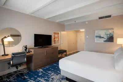 a hotel room with a bed and a desk and a television at Crowne Plaza Albany - The Desmond Hotel in Albany