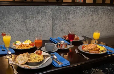 a table topped with plates of breakfast foods and drinks at Crowne Plaza Albany - The Desmond Hotel in Albany
