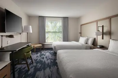 a hotel room with two beds and a desk at Fairfield Inn & Suites by Marriott Williamstown in Williamstown