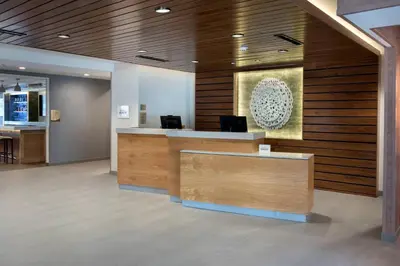 an office lobby with a reception desk and wooden walls at Fairfield Inn & Suites by Marriott Williamstown in Williamstown