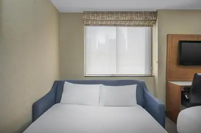 a bed in a room with a window and a television at Holiday Inn Express Manhattan Midtown West by IHG in New York