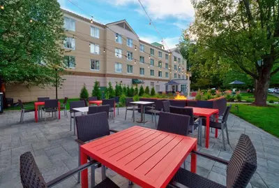 a patio with tables and chairs and a building at Hilton Garden Inn Saratoga Springs in Saratoga Springs