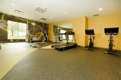 a gym with several exercise equipment in a room at Hilton Garden Inn Saratoga Springs in Saratoga Springs