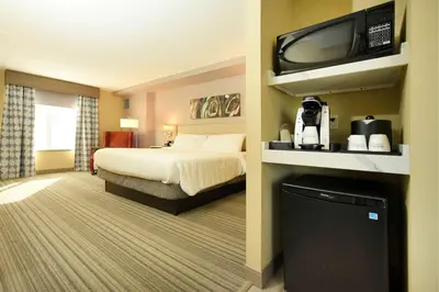 a hotel room with a bed and a flat screen tv at Hilton Garden Inn Saratoga Springs in Saratoga Springs