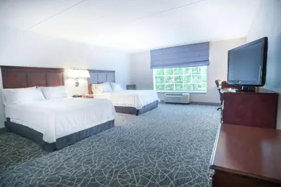 a hotel room with two beds and a flat screen tv at Hampton Inn & Suites Berkshires-Lenox in Lenox