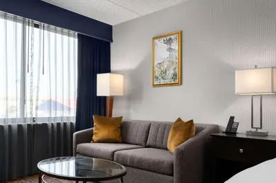 a living room with a couch and a glass table at DoubleTree by Hilton Bradley International Airport in Windsor Locks