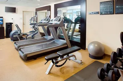 a gym with several treadmills and cardio machines at Hilton Garden Inn Hartford North-Bradley International Airport in Windsor