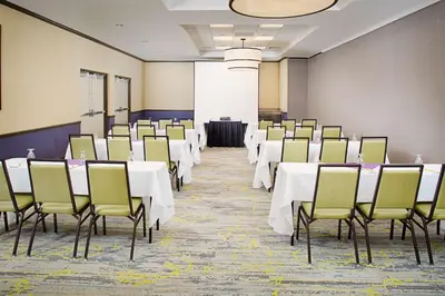 a conference room with white tables and chairs at Hilton Garden Inn Hartford North-Bradley International Airport in Windsor