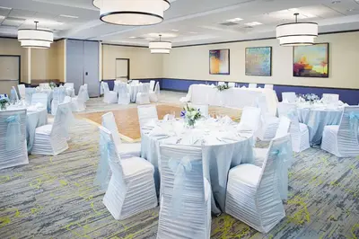 a banquet hall with white tables and white chairs at Hilton Garden Inn Hartford North-Bradley International Airport in Windsor