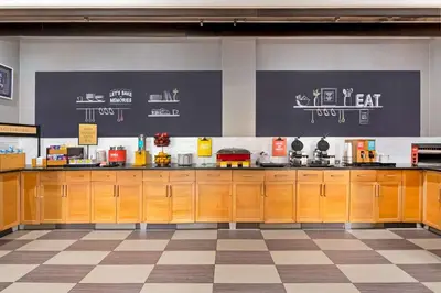 a large kitchen with wooden cabinets in a restaurant at Hampton Inn & Suites Stamford in Stamford
