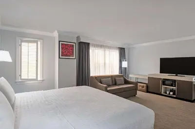 a hotel room with a bed and a flat screen tv at Hampton Inn & Suites Stamford in Stamford