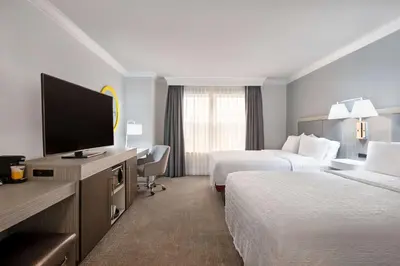 a hotel room with two beds and a flat screen tv at Hampton Inn & Suites Stamford in Stamford